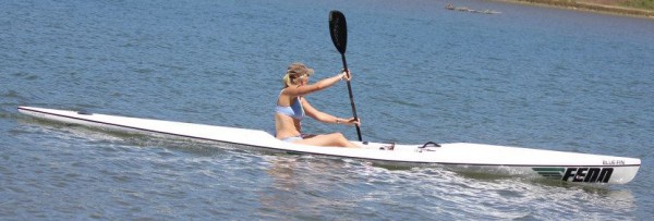 photo of a woman in a bikini paddling a Fenn Bluefin surf ski on flat water
