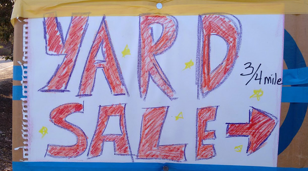 Sign with hand lettering "Yard Sale" and an arrow with the marking 3/4 mile