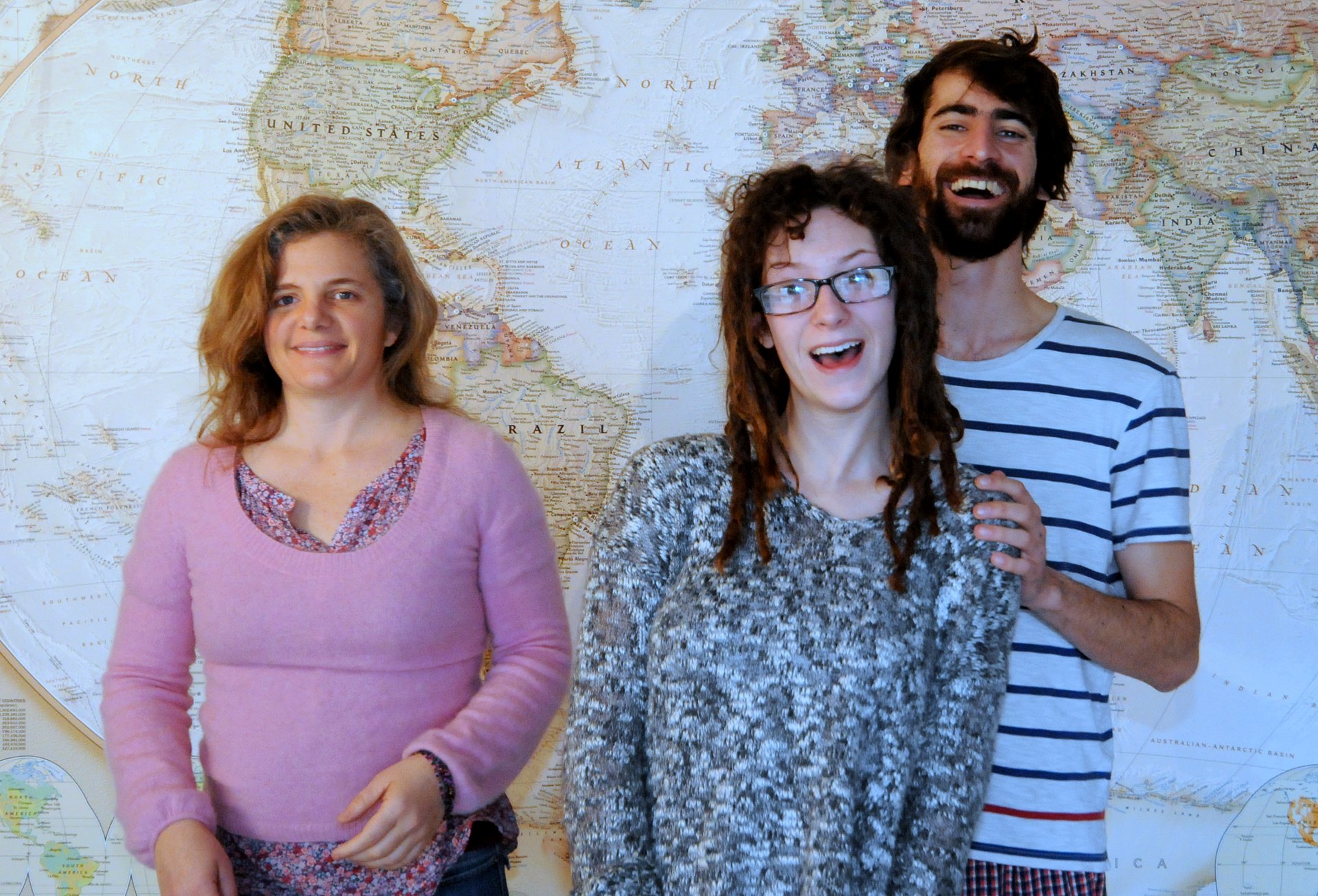 Julia, Rachel & Simon standing in front of a map of the world