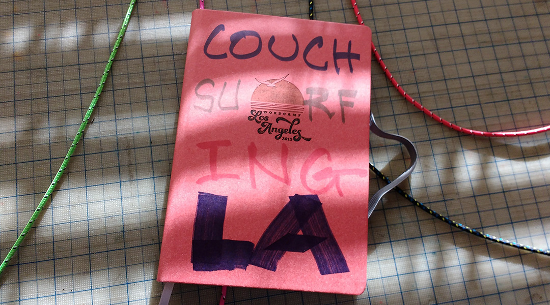 Photo of a journal with a red cover and the text "CouchSurfingLA" written on the cover in marker.