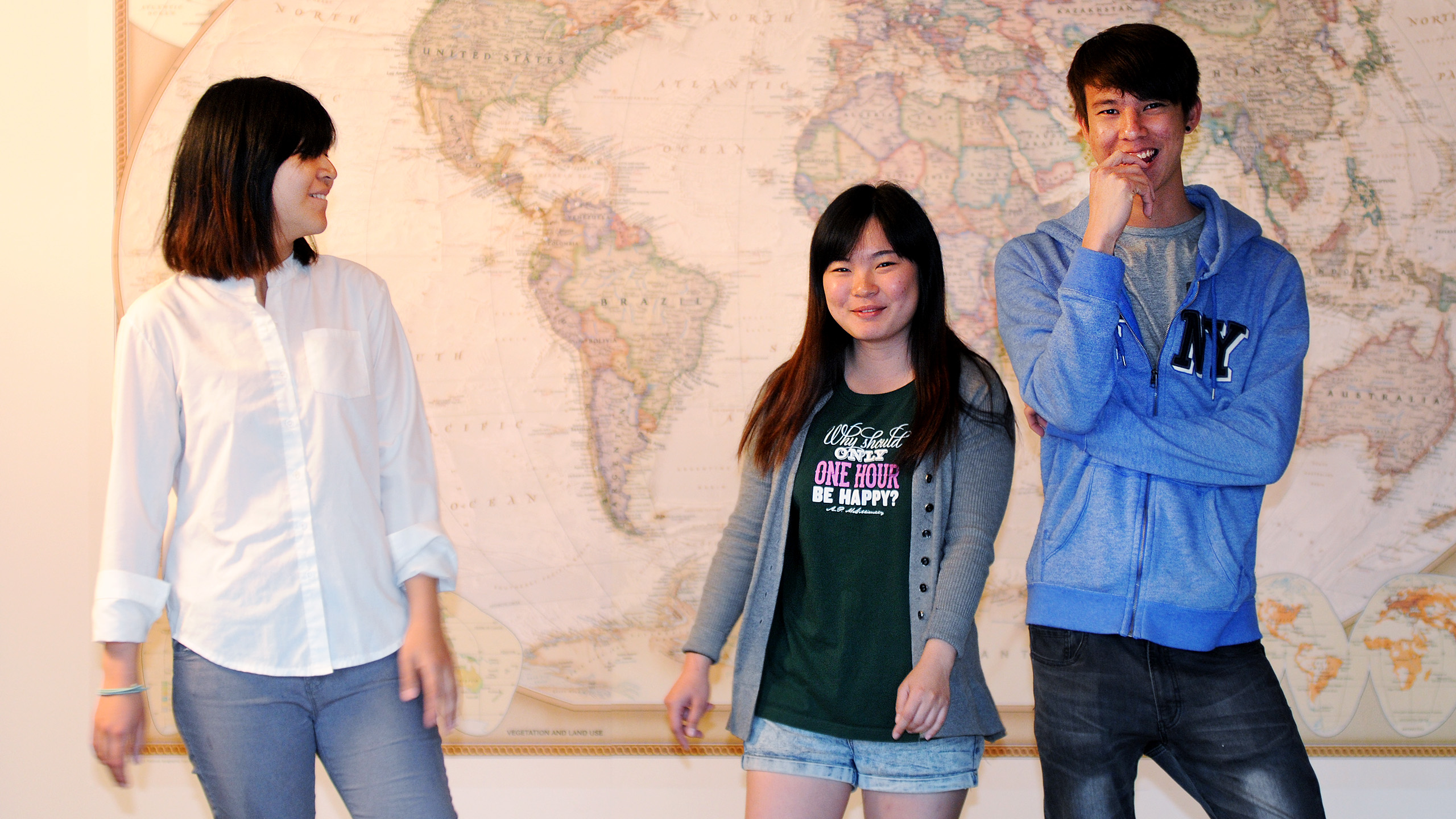 Ada, Joey & Kevin from Mayaysia standing in front of a large world map