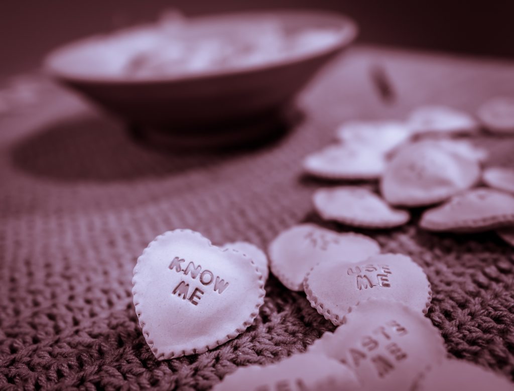 Claudia Solorzano's Ceramic-ravioli-candy-heart with the words "Know Me" on it.