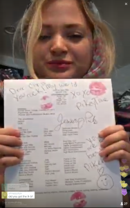 Screen cap of Periscope video app showing Jessica Pike, aka @PikeyTime holding up a headshot that she's autographed and added lipstick kiss prints to