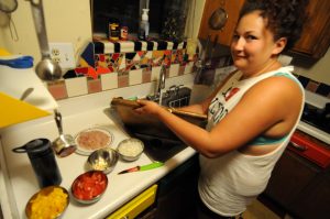 Csenge chopping ingredients in the kitchen