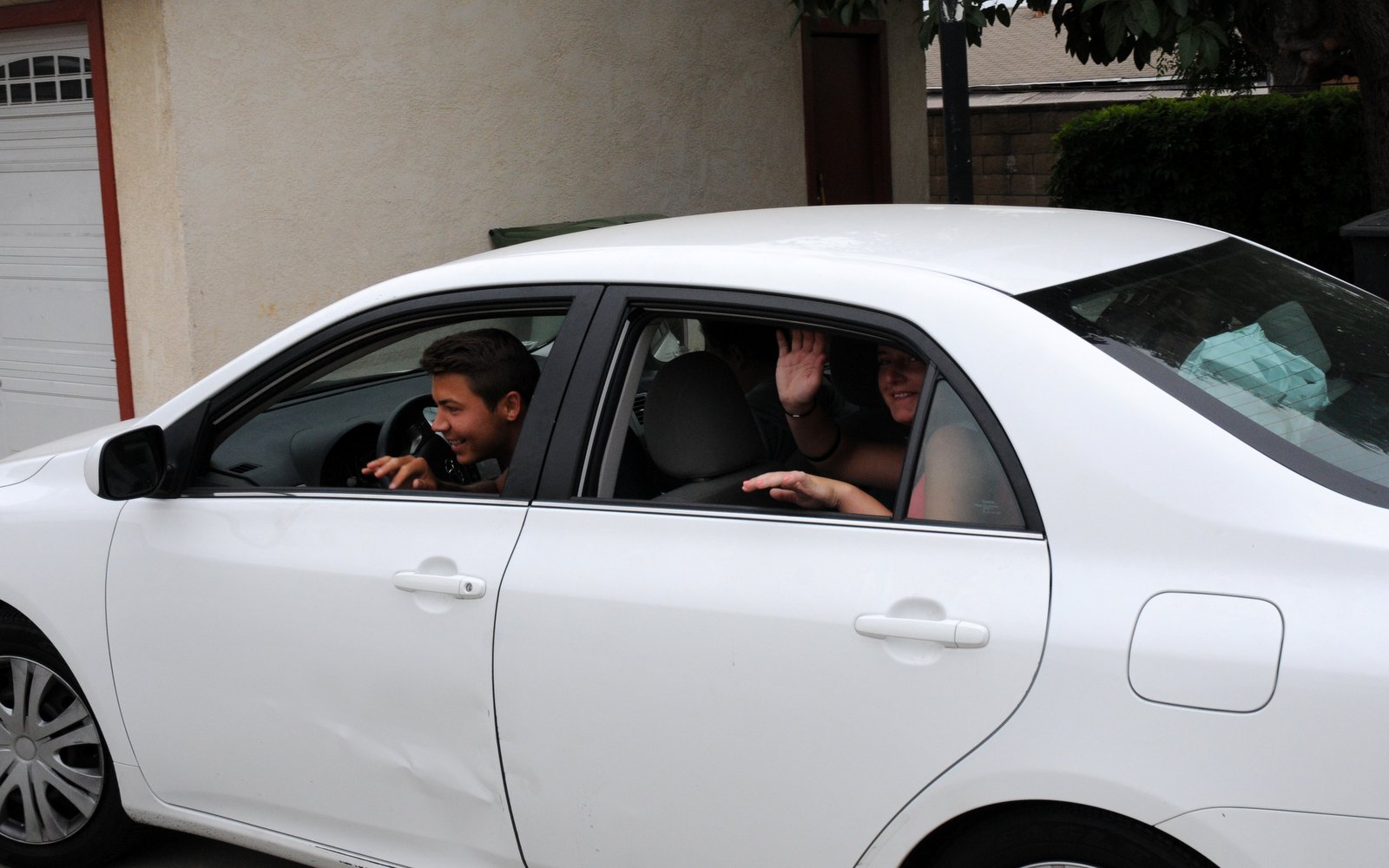 Akos & Eszter wave out of the driver's side of the car