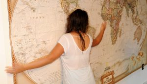 Elena "hugging" a giant wall-sized map of the world