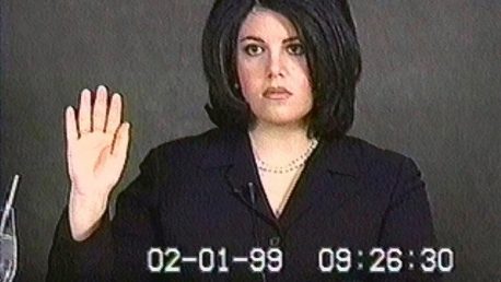 Video frame of Monica Lewinsky raising her hand to be sworn in for testimony. The frame has the date 02-01-99 burned into it.