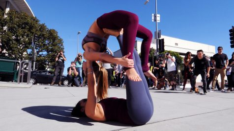 Two dancers making a configuration on the ground in front of Disney Hall on Grand Avenue in Downtown Los Angeles