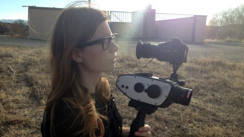 Elle Schneider in a field holding the Digital Bolex camera that she helped create
