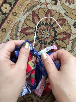 hands tying knots in fabric strips