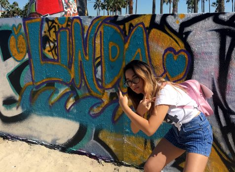 Linda-Linh Nguyen in front of her name on a wall at the Venice Beach, CA Art Walls