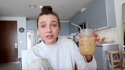 frame from an Emma Chamberlain YouTube video showing her holding a cup of iced coffee and grimacing