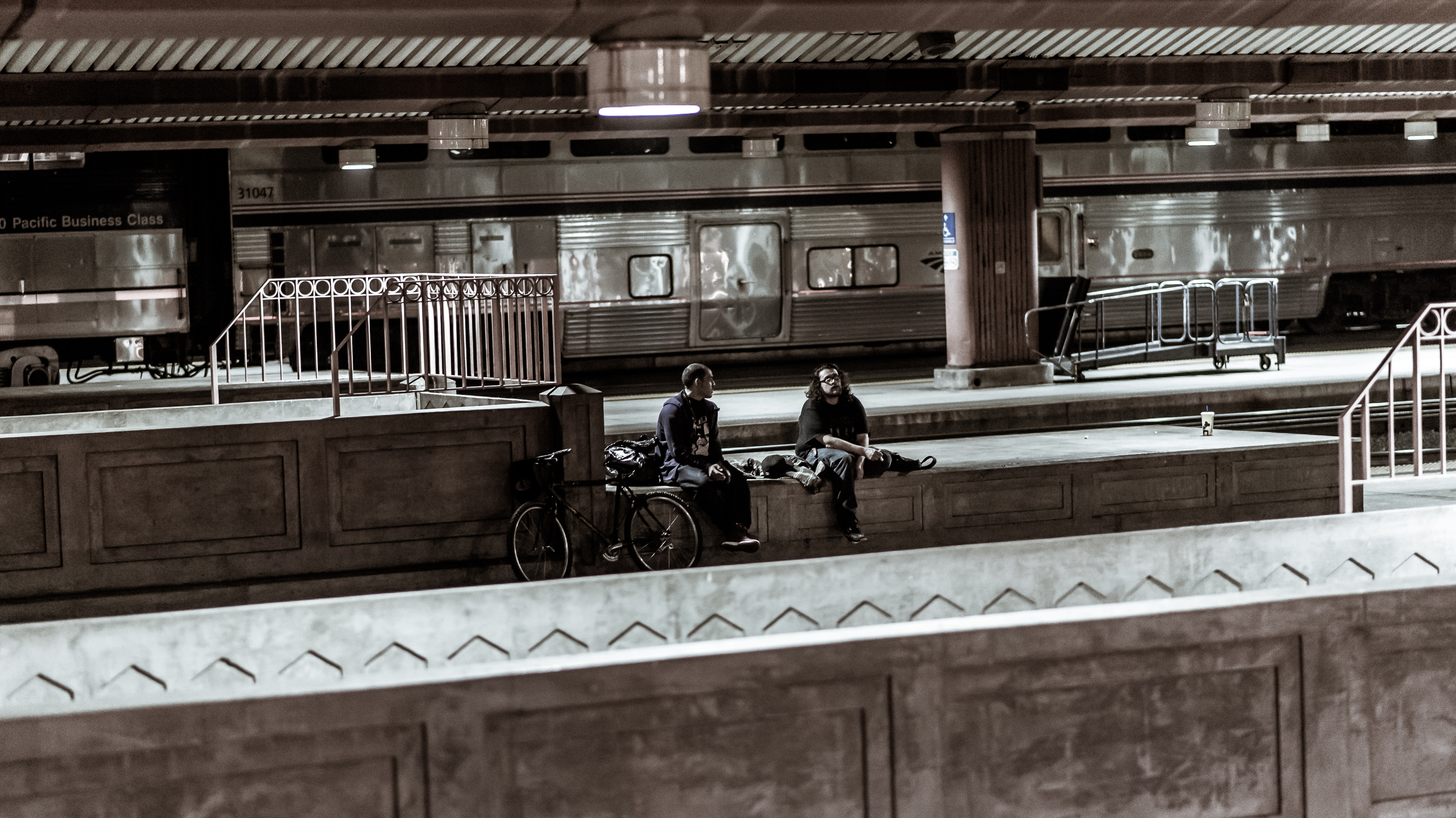 Two guys and a bicycle wait on a platform at Union Station in Los Angeles, for a Metrolink train.