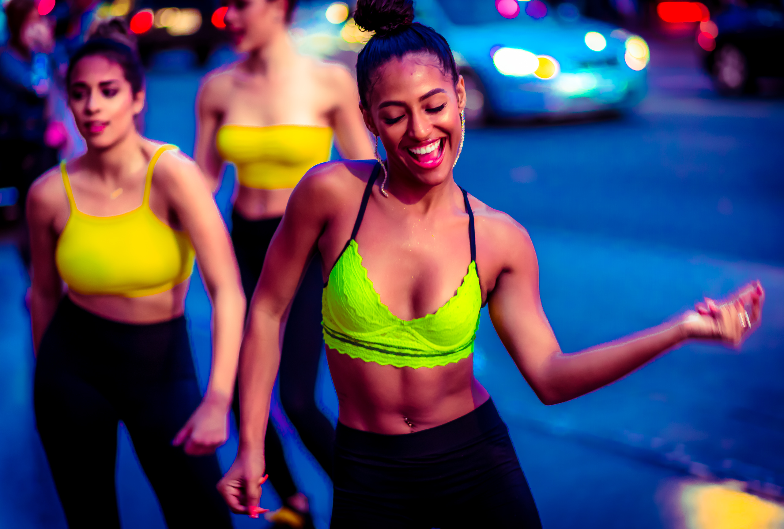 Dancers in green and yellow tops and black pants perform for a dance video on Hollywood Blvd.