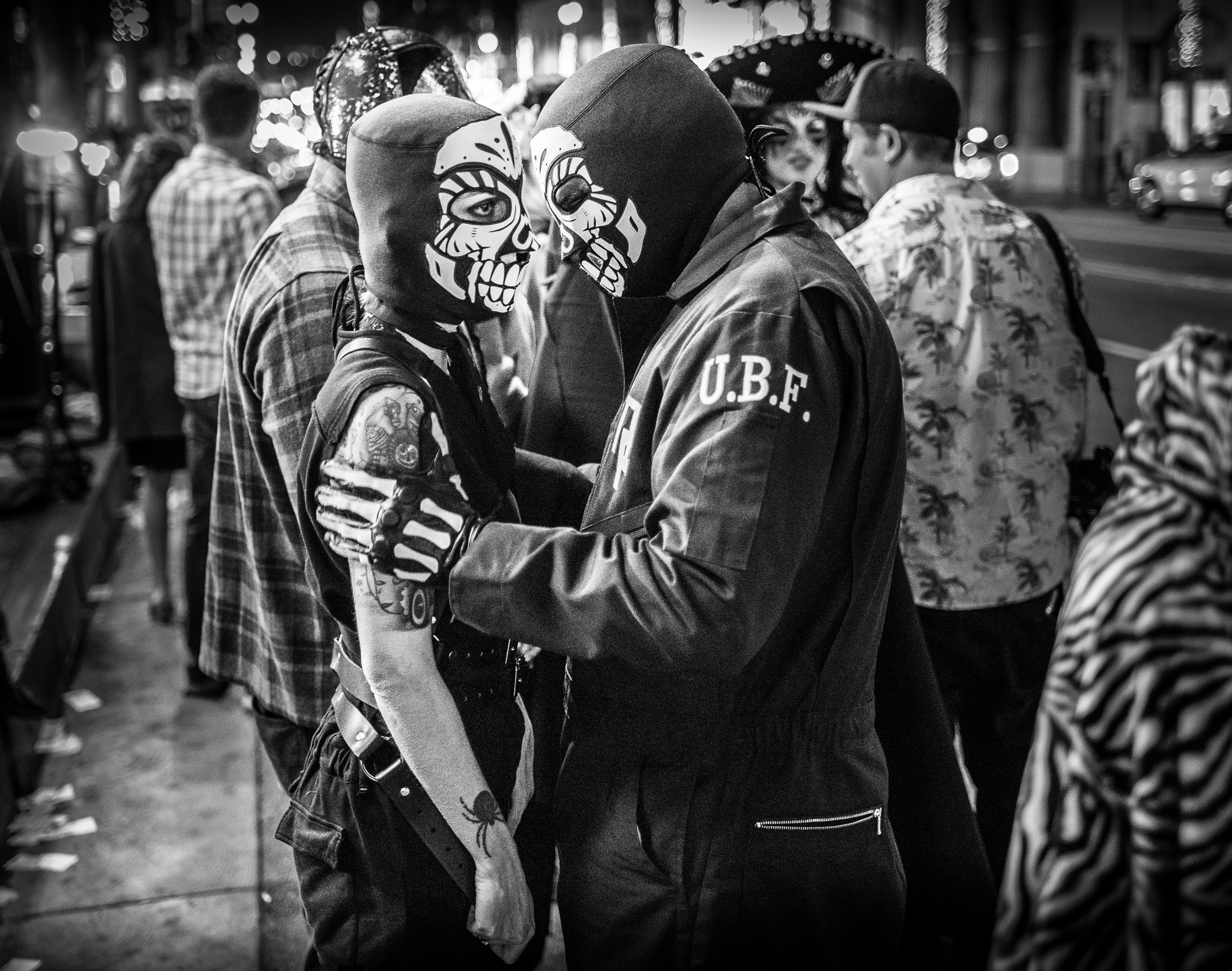 two people in skeleton costumes share a tender moment on the street. Hollywood Blvd, Hollywood, California.