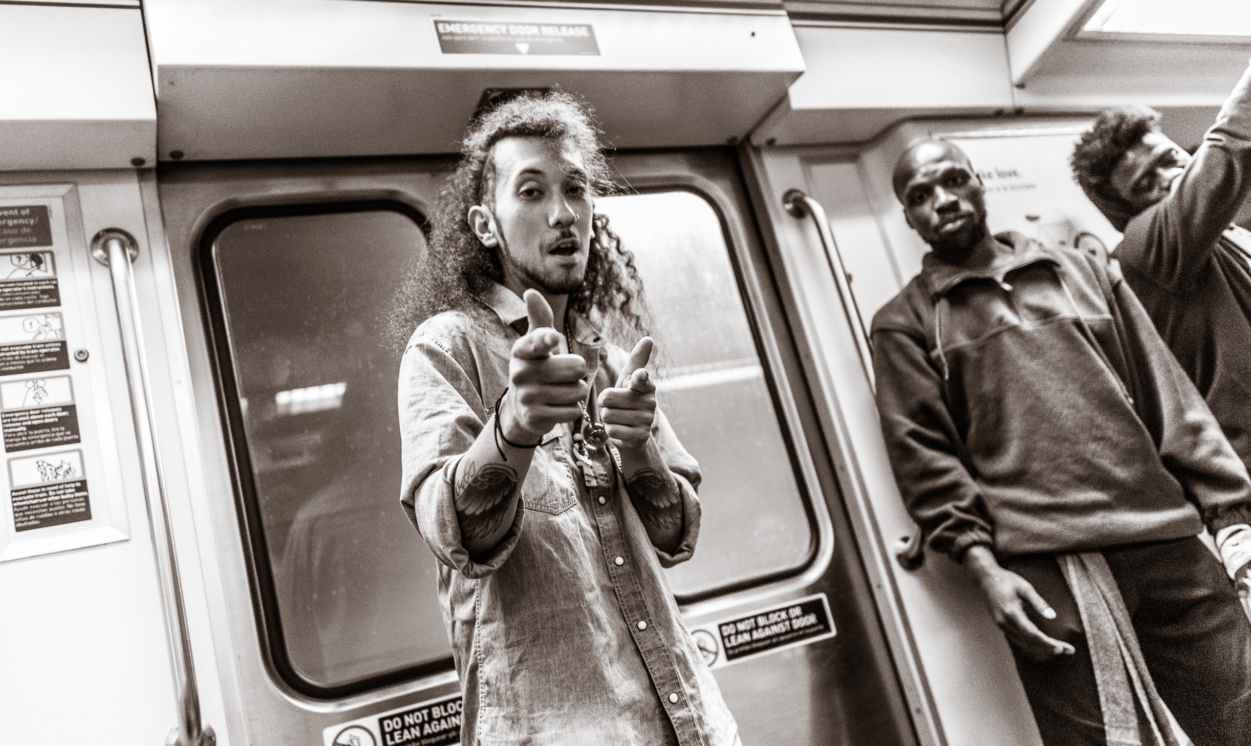 a dancer on a Metro Red Line train points his fingers at the camera