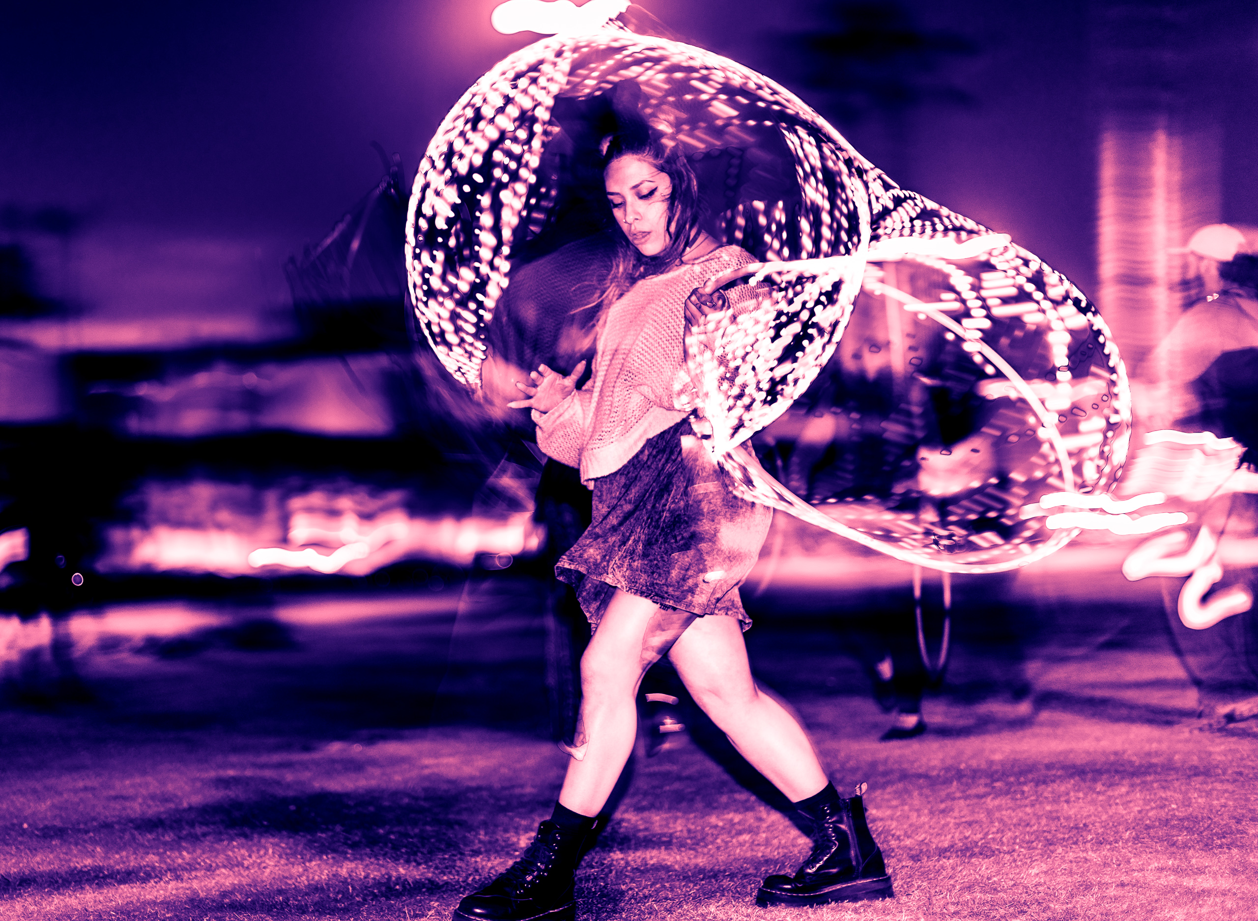 Alli Wolf, aka @wolfamongweeds, Los Angeles based DJ, Producer, Flow Artist, Techno, dancing with an LED hoop at Venice Glow Flow in the park at Venice Beach, CA