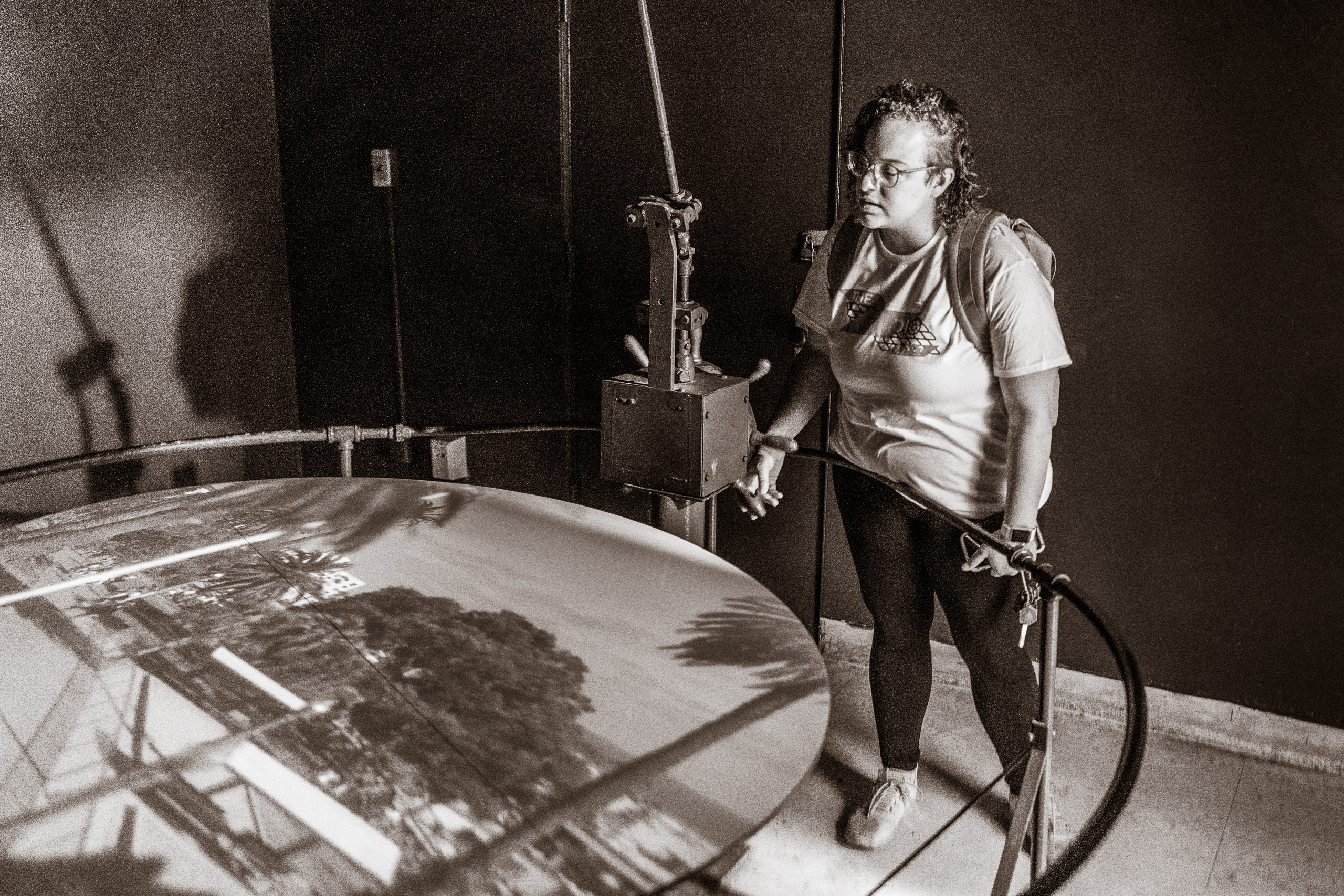 Santa Monica, CA Camera Obscura Art Lab artist-in-residence Brittany Ransom turns a wheel in the camera obscura room and views the resulting projection on the surface of a large, white table