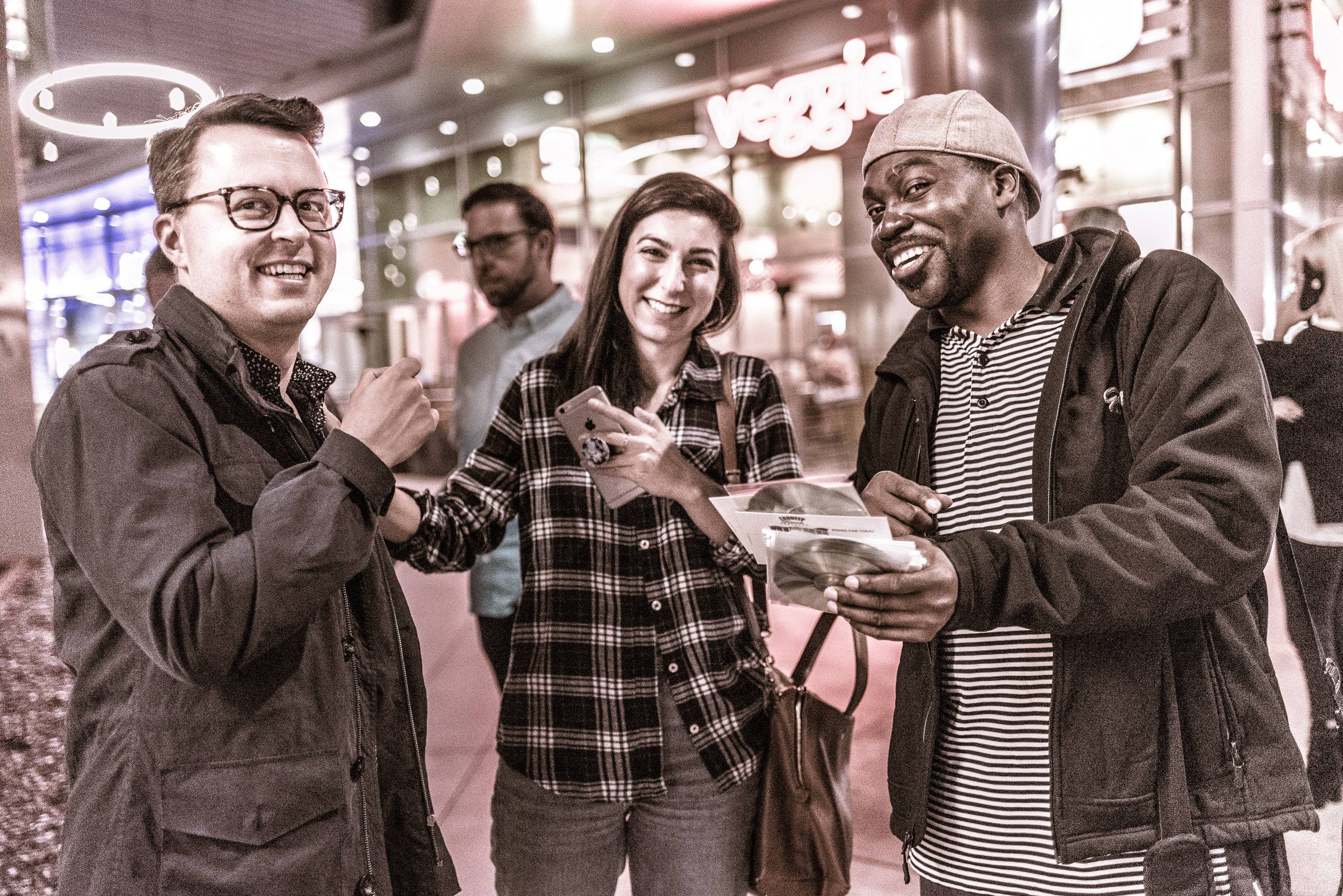a musician tries to sell one of his CDs to a couple passing through the Arclight Cinema Courtyard on Sunset Blvd in Hollywood