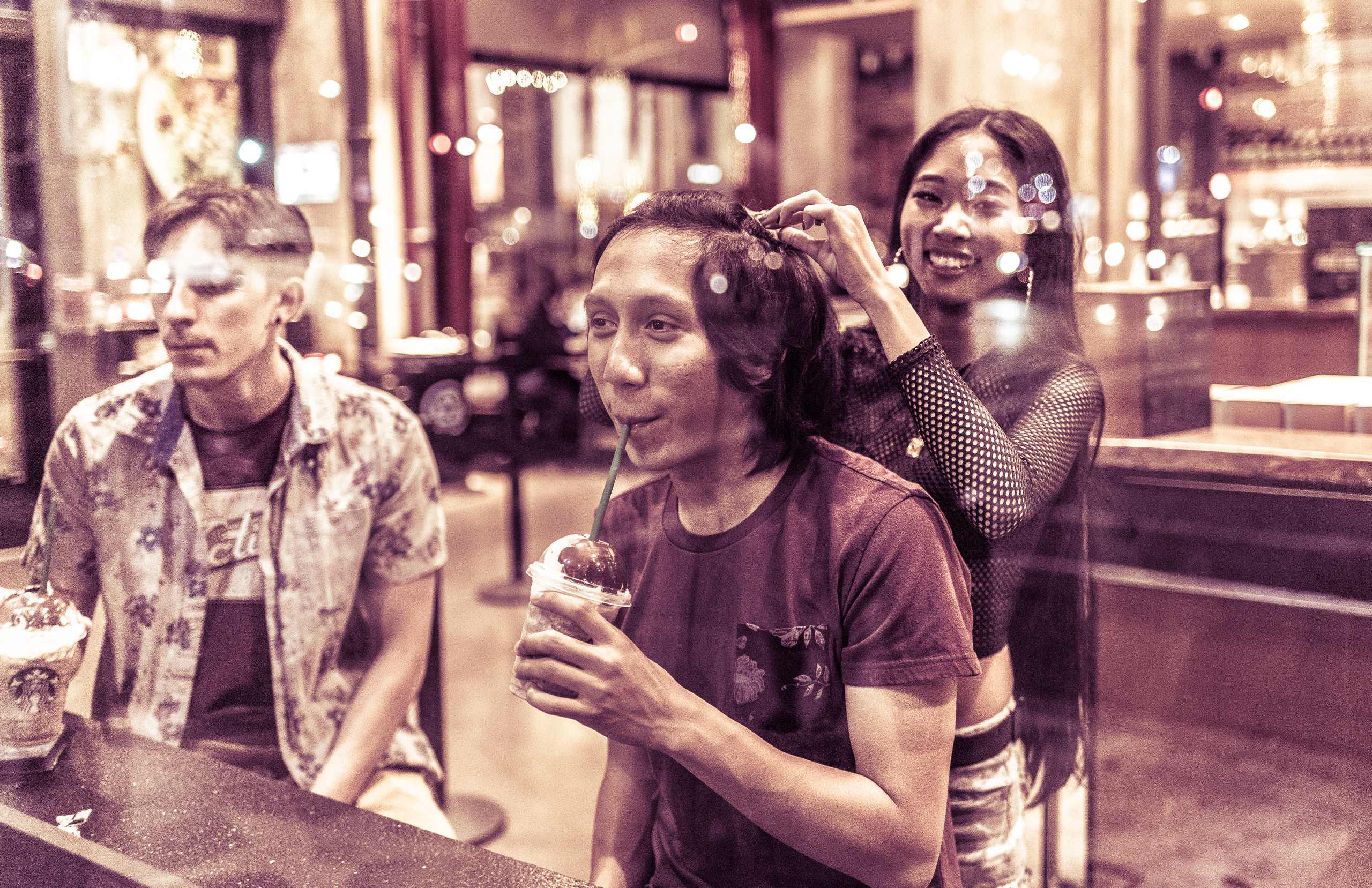 through the window of a Popeyes on Hollywood Blvd, a girl arranges her boyfriend's hair