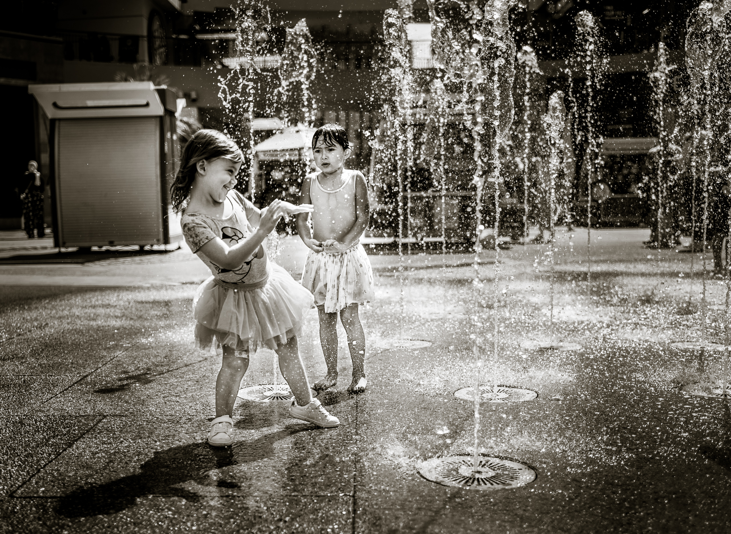 two small girls play in the fountain at the Hollywood & Highland shopping center in Hollywood, California