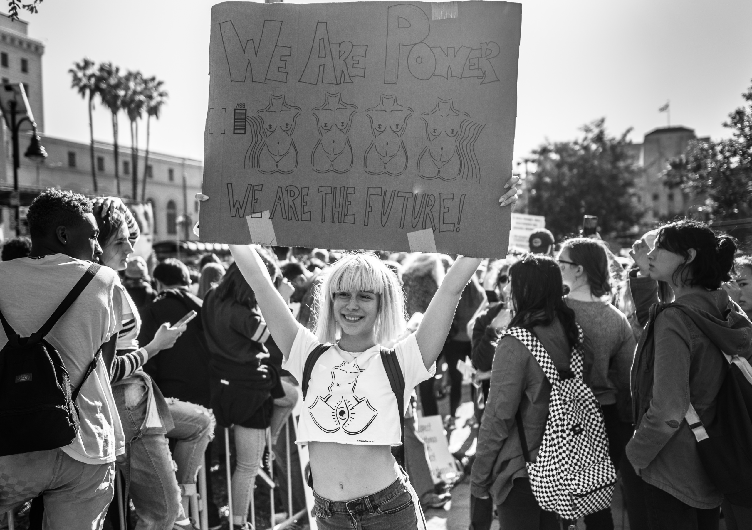 a woman holds a sign reading "We are power, we are the future"