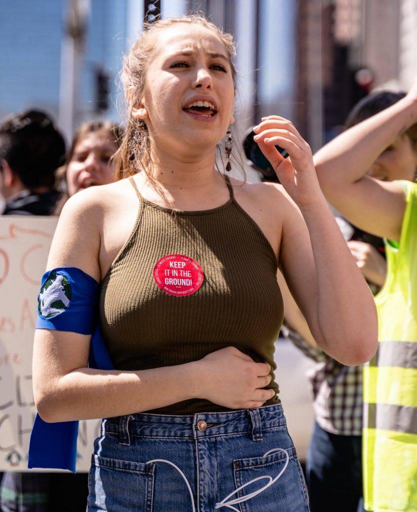 Los Angeles Youth Climate March organizer Arielle Martinez-Cohen, 17, a senior at New West Charter School in West Los Angeles marches in Downtown Los Angeles on Friday, March 15, 2019. Of the march, Martinez-Cohen said, "It’s super exciting to see all these students fighting for the same cause." When asked what comes next, she offered, "We want to bring our demands to our city hall legislators. We want to have Los Angeles carbon neutral by 2030. We’re on schedule for 2045, but that’s not soon enough. The City of Los Angeles has been taking the initiative, and we don’t want to spread hate, we want to spread love. But we can’t wait till 2045. We have to be 100% carbon neutral by 2030." (Glenn Zucman/The Corsair)