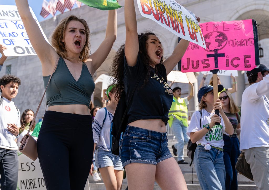 Aubrey Gilman (in the black t-shirt), 18, from UCLA, carries her "You turned the temperature hotter, now we’re burning up!" sign in the Youth Climate Strike at Los Angeles City Hall on Friday, March 15, 2019. Gilman said she came to the climate strike because, "Since the adults aren’t making a change, the students have to step in and do it for them." "Fridays for the Future" is organized by 16-year-old Swede Greta Thunberg. The Los Angeles Youth Climate March is organized by 17-year-old Los Angeleño Arielle Martinez-Cohen. (Glenn Zucman/The Corsair)