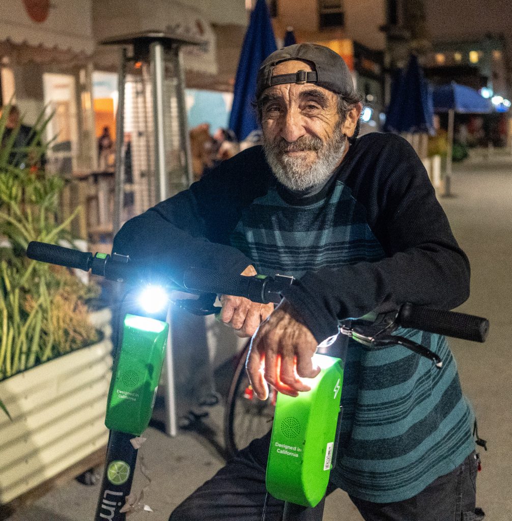 "Scooter Keeper" Alex, 61, From Santa Monica, Calif., With Lime EScooters He Has Collected In The Venice Beach Area On The Evening Of Thursday, Feb. 28, 2019. Alex Will Take The EScooters Home With Him To Charge Them And Then Put Them Back Out. Lime Pays Him $5 Per Scooter. Alex Stopped Collecting Bird EScooters When They Dropped The Pay From $5/Scooter To $3/Scooter. Alex Knows That Some Companies Like Uber And Lyft Have Full-Time Jobs Collecting EScooters, But He Doesn't Want That Kind Of Constraint At His Age. He Enjoys The Freedom Of Collecting EScooters When He Chooses. (Glenn Zucman/The Corsair)