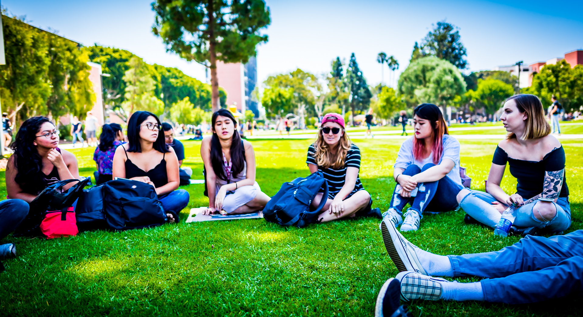 Students sitting on the grass outside the FA4 building on the Long Beach State University campus