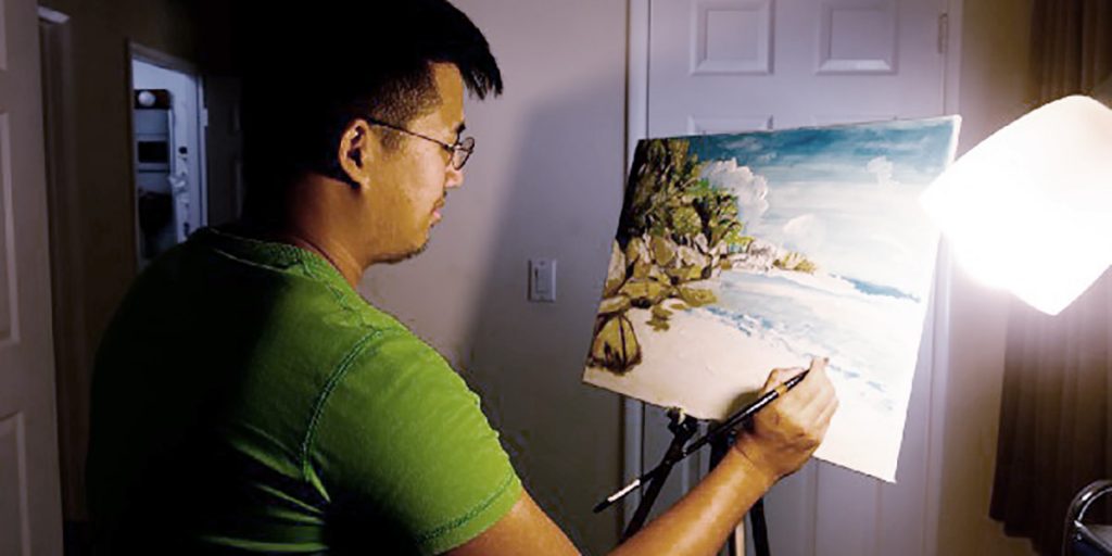 photograph of painter Alex Wu at work in his studio