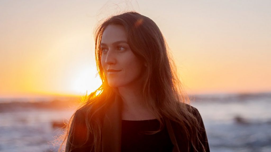 photo of artist Nicolette Cussins at the beach at sunset