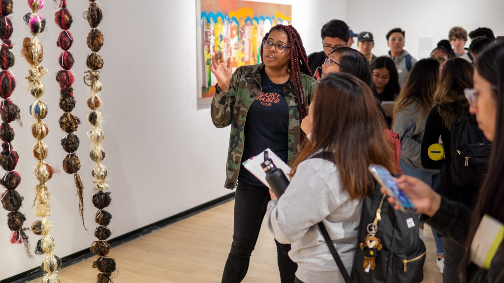 Students discuss work with an artist in the Max Gatov Gallery at Long Beach State University's School of Art.